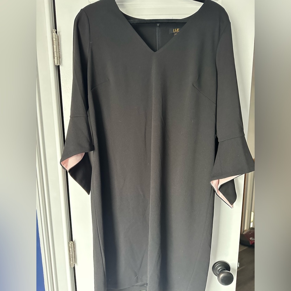Stunning black dress with pink accent inside sleeve.